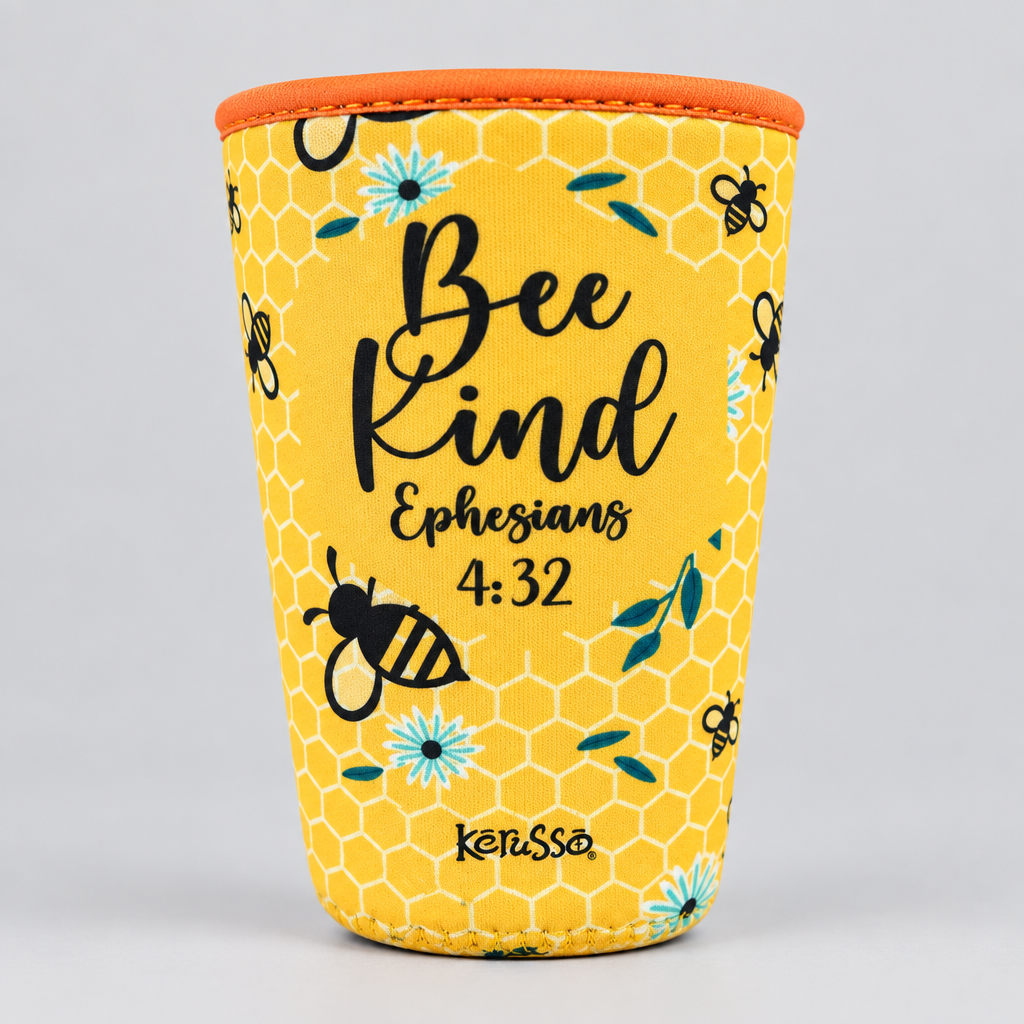 A yellow neoprene cup sleeve with a honeycomb pattern, featuring a bee, blue flowers, and the text 'Bee Kind Ephesians 4:32' in black script. The sleeve has an orange rim and the brand name 'keussa' printed near the bottom.